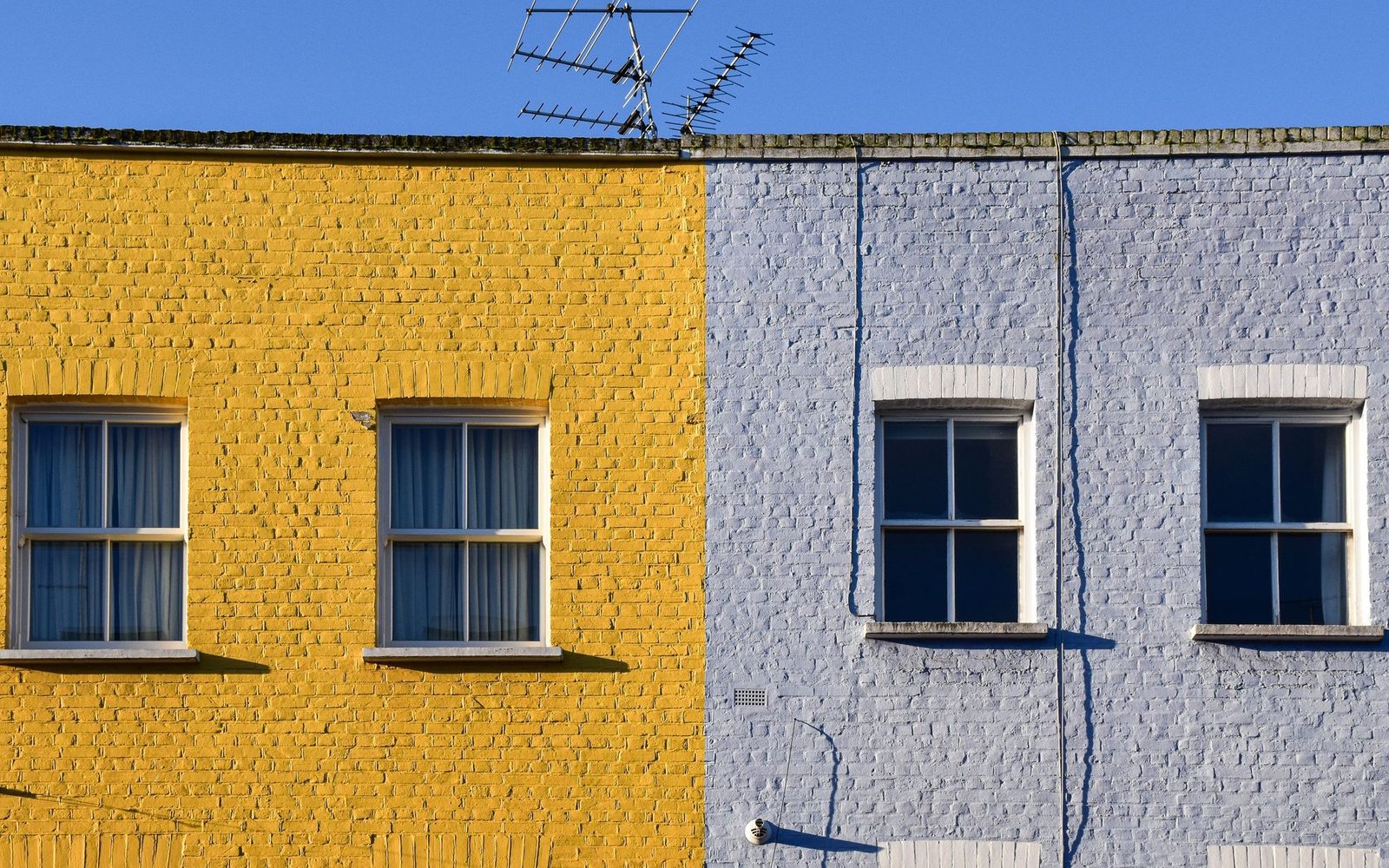 Painted brick terraced house fronts with white sash windows