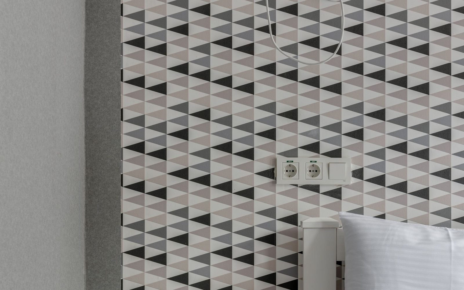 Patterned wallpaper hung on a bedroom feature wall