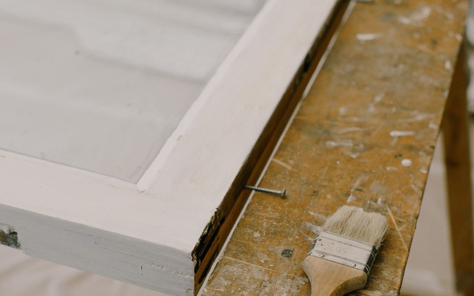 Freshly painted window frame and brush on a workbench